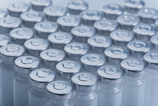 Glass medical ampoule vial for injection. Medicine is dry white drug penicillin powder or liquid with of aqueous solution in ampulla. Close up.