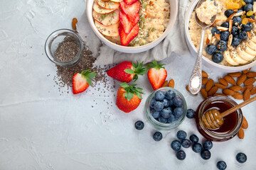 Oatmeal bowls with delicious fruits and fresh berries on light background.