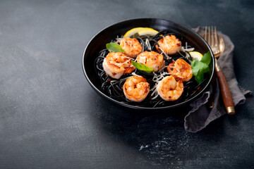 Spaghetti with shrimps and parmesan on dark background. Tasty appetizings seafood pasta.