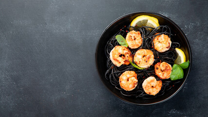 Spaghetti with shrimps and parmesan on dark background. Tasty appetizings seafood pasta.