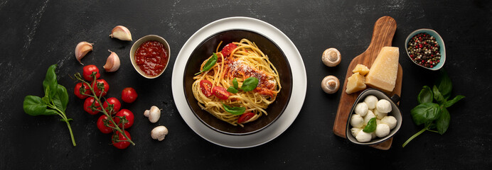 Assortment of Italian pasta with traditional sauces for dinner on dark background.