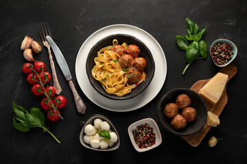 Assortment of Italian pasta with traditional sauces for dinner on dark background.