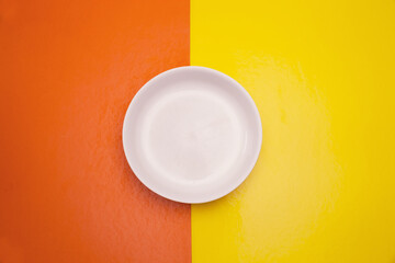 
white plate on yellow and orange table