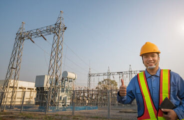 Happy electrical substation engineer inspect modern high-voltage equipment use tablet computer.Energy Industry technology