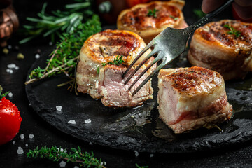 meat Steak filet mignon. medallion steaks wrapped in bacon on dark concrete background