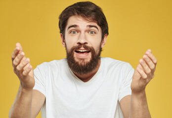 Close up portrait man with brunet beard white t-shirt yellow background