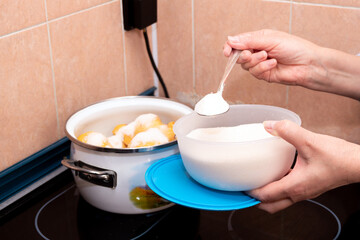 Add sugar with a spoon to a pot of quince. The process of making jam. Selective focus.