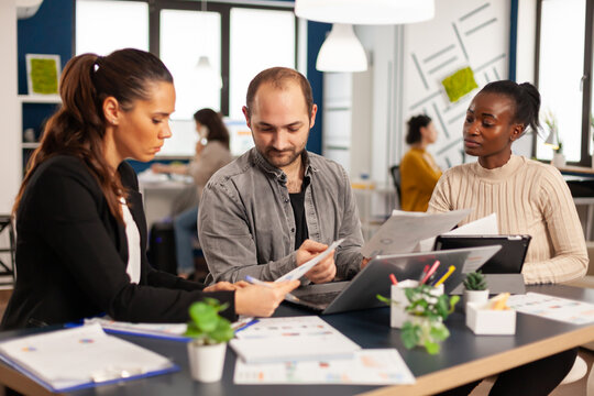 Team of diverse startup company colleague entrepreneur meeting in professional workplace, brifing and sharing ideas over financial strategy management. Multiracial business people working together.