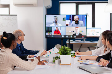 Headshot screen application view of remote multiracial employees talking on video call brainstorm...