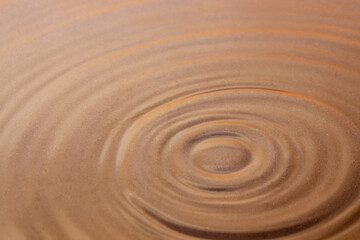 Fototapeta premium Circles on the surface of the water close-up. Under the water, you can see the sandy bottom