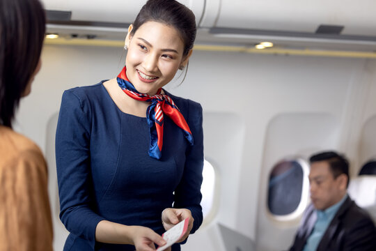 Cabin crew or Stewardess greeting passengers on airplane, Air hostess or stewardess service