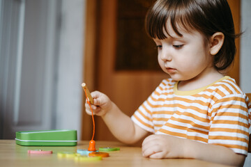 Early baby development. Homeschooling a young autistic child. The kid learns to play the game of...