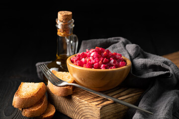 salad vinaigrette in a wooden cup on a dark background