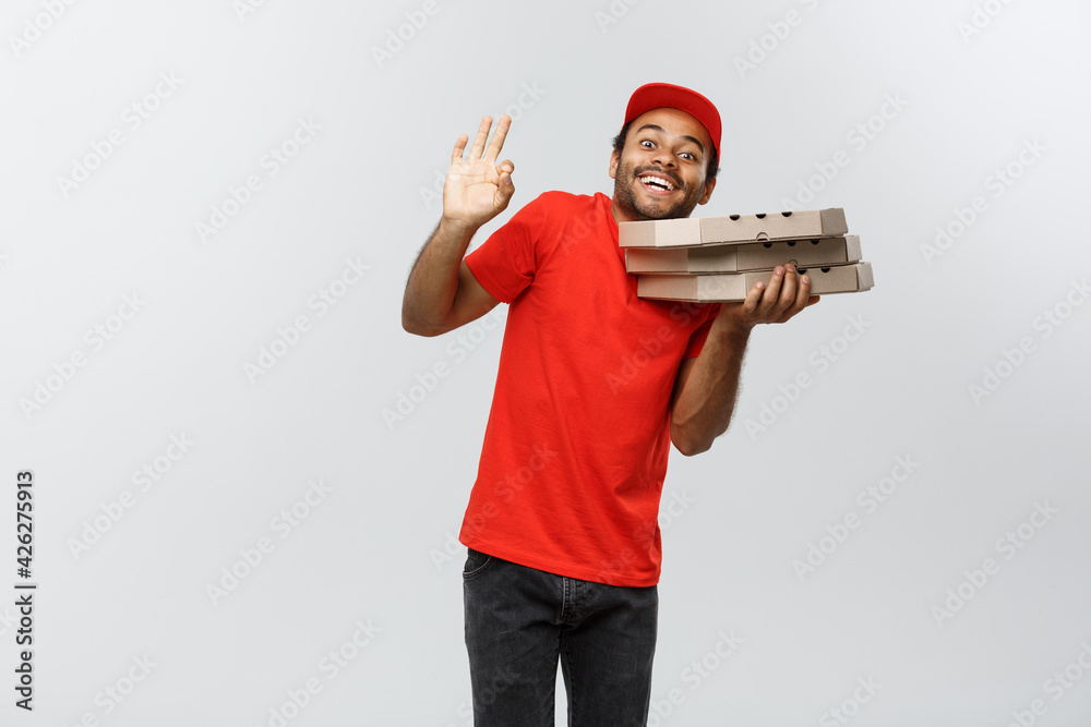 Wall mural delivery concept - portrait of handsome african american pizza delivery man. isolated on grey studio