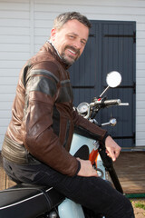 Fototapeta na wymiar handsome happy smile man rider aside vintage motorcycle