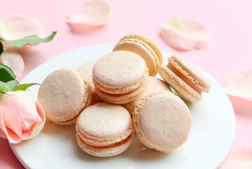 Obraz na płótnie Canvas Pastel pink Macarons on white plate of the pink background at close up view - sweet and love concept