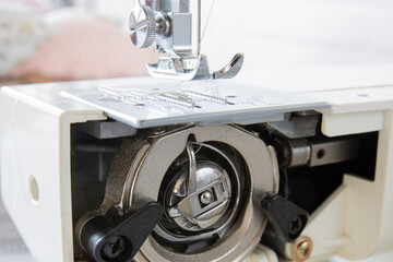 Bobbin Case Beneath The Sewing Machine. shiny parts