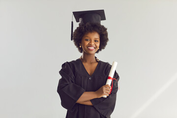 Graduation. Young african american college or university student in academic hat, gown with...