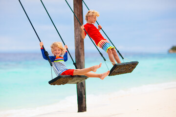 Child on beach swing. Summer vacation.