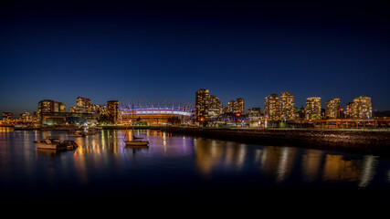 Fototapeta na wymiar Vancouver Skyline at night with BC Place Stadium Lit Up at the North Shore of False Creek Inlet at night, British Columbia, Canada