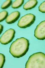 Fresh ripe cucumber slices on mint background