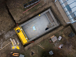 aerial drone shot of construction site from pool with formwork for concrete and finished brick wall from above