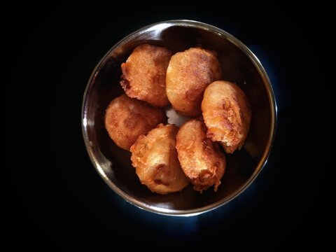 kobbari burelu,festival sweet with rice flour and coconut in the steel bowl on a black background, India