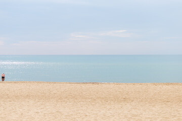 Fototapeta na wymiar Minimalism photo. Beach, sky and sea line. One woman in sea cloth.