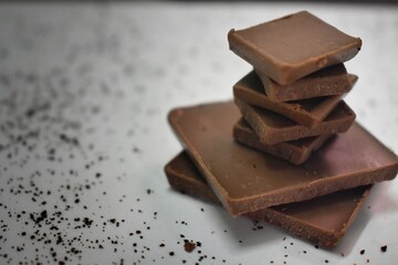 Milk chocolate pieces isolated on white background from top view