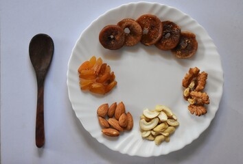 with mixed nuts on white table top view. Healthy food and snack. Walnut, pistachios, almonds, hazelnuts and cashews.