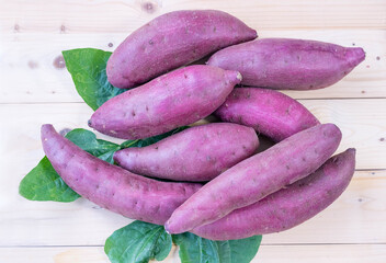 Top view Fresh sweet potato closeup, Japanese Sweet Potato on wooden table in garden.