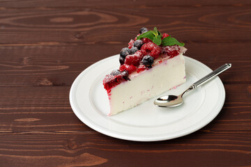 Piece of berry cheesecake served on brown wooden table
