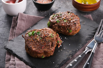 Grilled beef fillet steaks with herbs and spices on stone board. Two Fillet mignon. Fillet of beef.