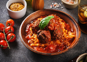 Meat balls in tomato sauce with stewed cabbage.