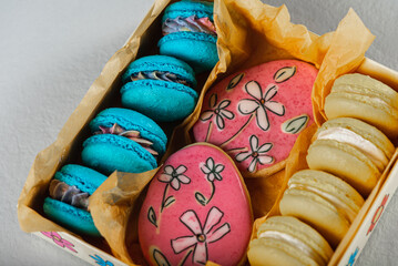 Fototapeta na wymiar Sweet, tasty and colorful - blue and yellow french macarons and painted colored gingerbread on a light background. The dessert is sweet. Selective focus.