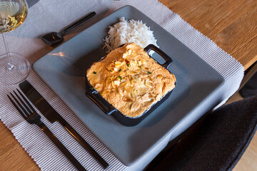 Fish in a casserole with meringue almond topping cooked in the oven with rice.