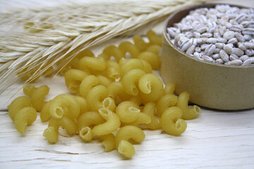 Dry wheat pasta on a wooden background.