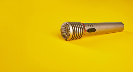 Microphone close-up on a yellow background.