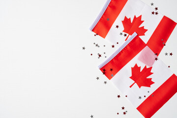 Happy Canada Day banner design. Canadian flags and confetti on white background. Flat lay, top view, copy space.