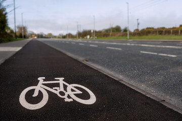 White bike sign on a asphalt on a separate lane for cycling by a motorway. Nobody