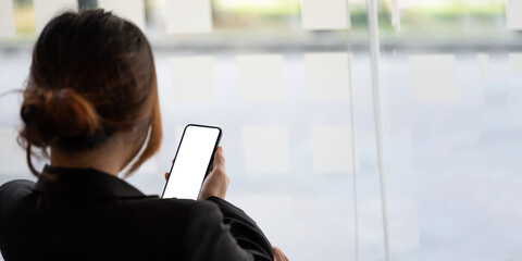 Close up business woman using smart phone with white blank screen at office