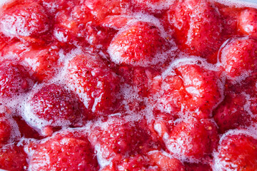 Cooking strawberry jam, red background of strawberry jam. Strawberry berries in jam