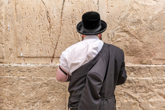 Undefined ultra-orthodox jewish person prays next to Western Wall in Jerusalem