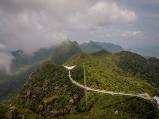 Langkawi Sky Bridge located 660 metres above sea level at the peak of Gunung Mat Cincang on Pulau Langkawi. Lots of peaks around the bridge. Clouds covering the sky completely.