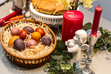 Easter table, basket with painted eggs and cake.