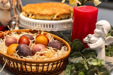 Easter table, basket with painted eggs and cake.