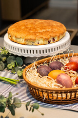 Easter table, basket with painted eggs and cake.