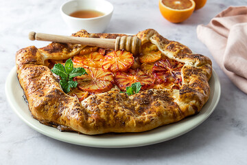 Red blood orange galette, seasonal pie with citrus. Tasty baking with honey and mint.