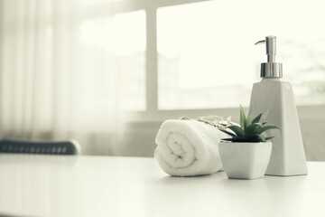 Soap dispenser and spa towel ,Roll up of white towels on white table with copy space,towels studio shot on white table