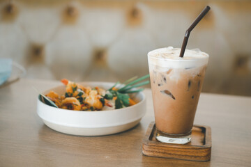 Iced coffee in a tall glass served with Thai food